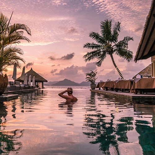 Man swimming in pool at tropical location