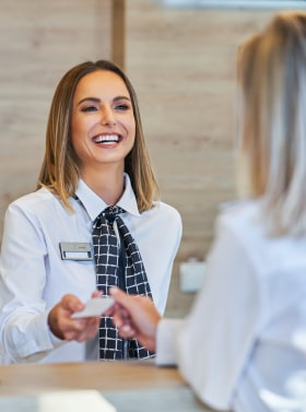 Hotel concierge handing a guest a pass