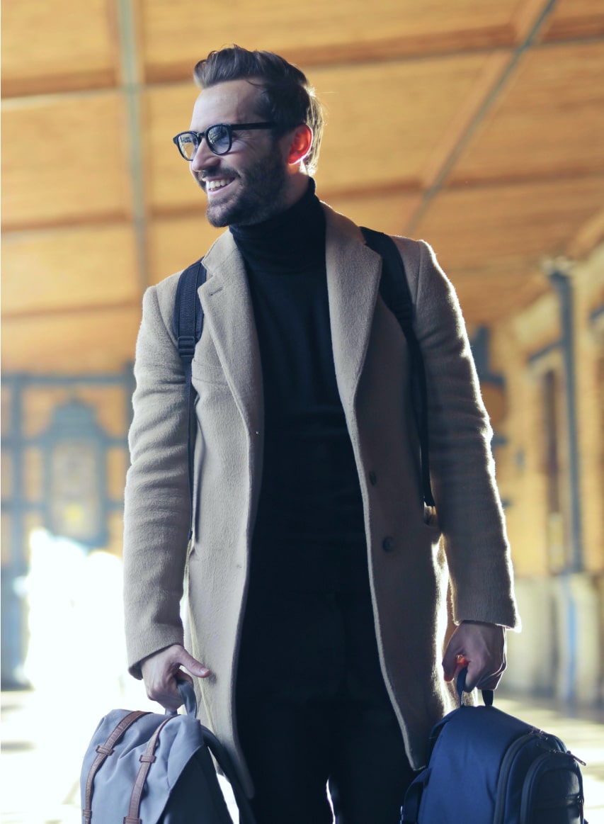 Business manning smiling and carrying travel bags