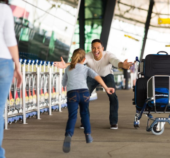 Young girl running into a mans arms at the airport